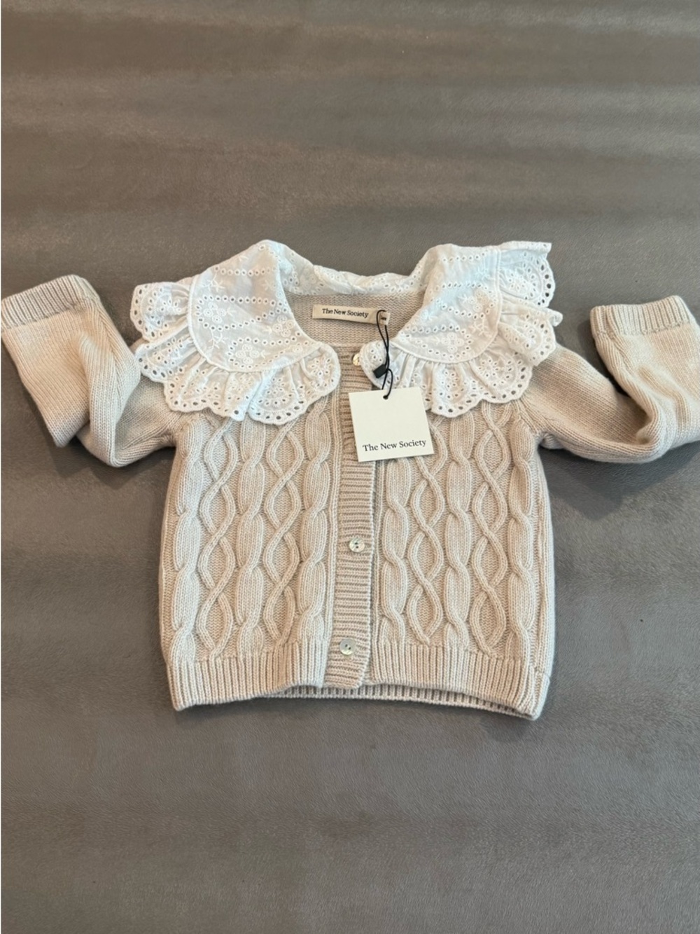 The New Society Cream Cable Knit Baby Cardigan with Eyelet Collar. Size 24